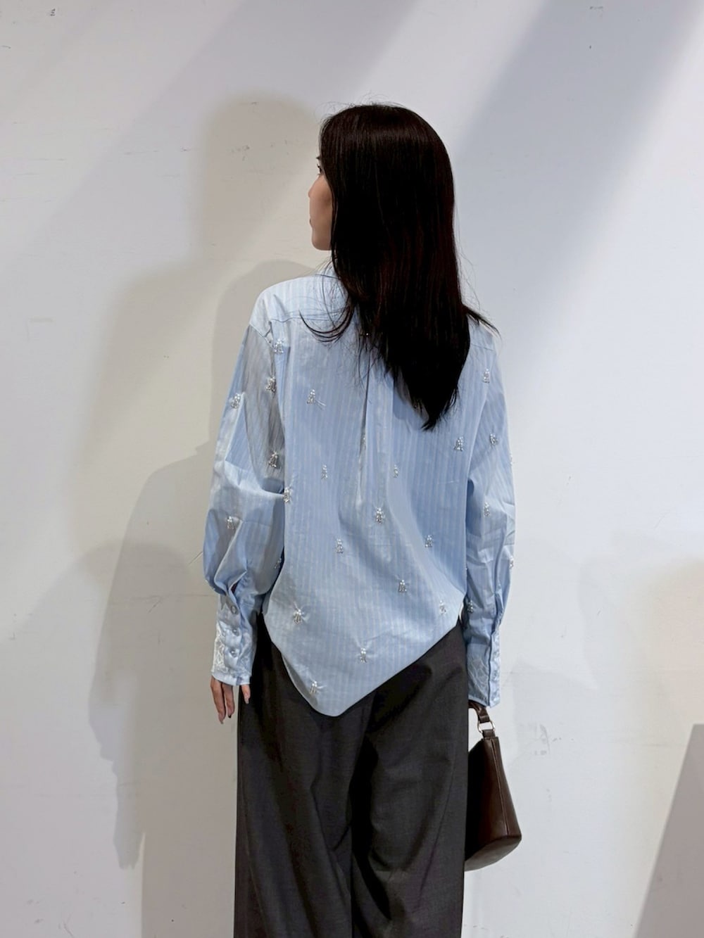 ブルー系のシャツ/ブラウス、グレー系のその他パンツ、ブラック系のブーツを着用したレディースの秋コーディネートの6枚目の写真