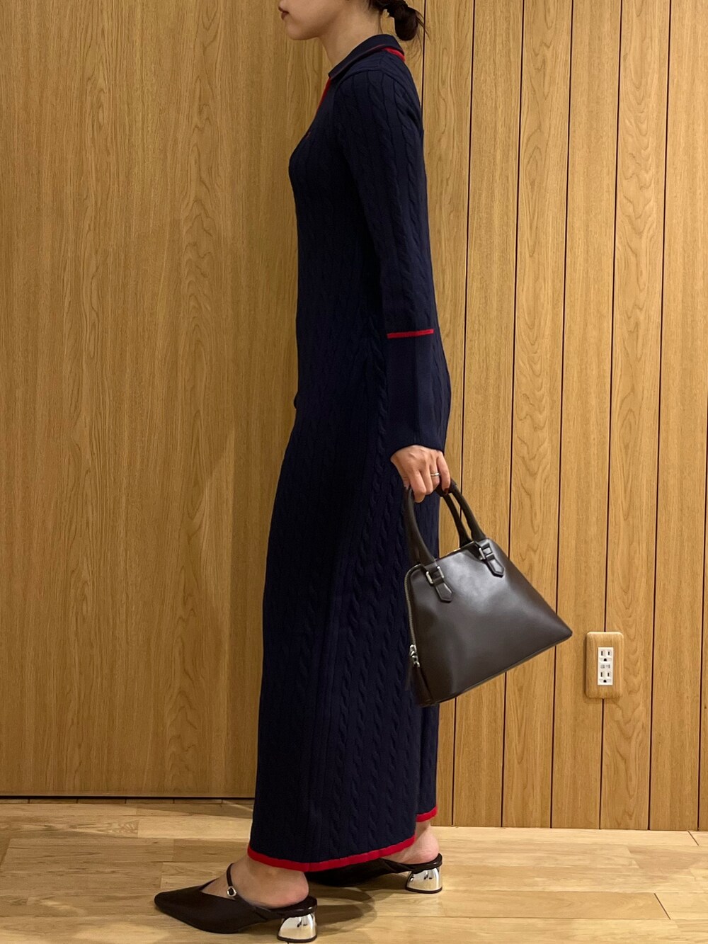 ブルー系のワンピース、ブラウン系のボストンバッグ、ブラウン系のパンプスを着用したレディースの秋コーディネートの2枚目の写真