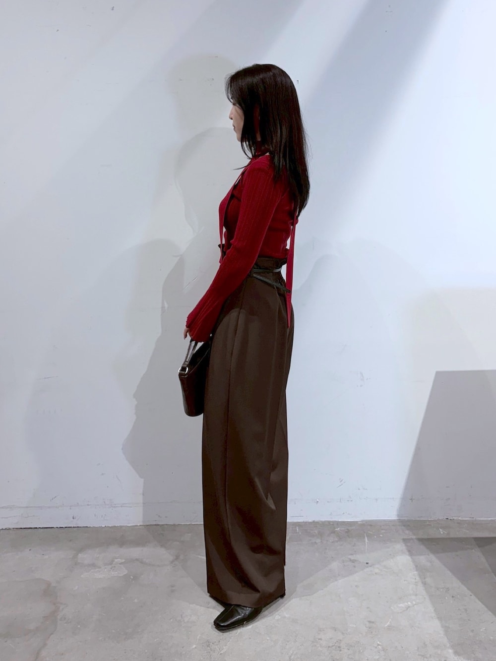 ブラウン系のその他パンツ、ブラック系のブーツ、レッド系のニット/セーターを着用したレディースの夏コーディネートの2枚目の写真