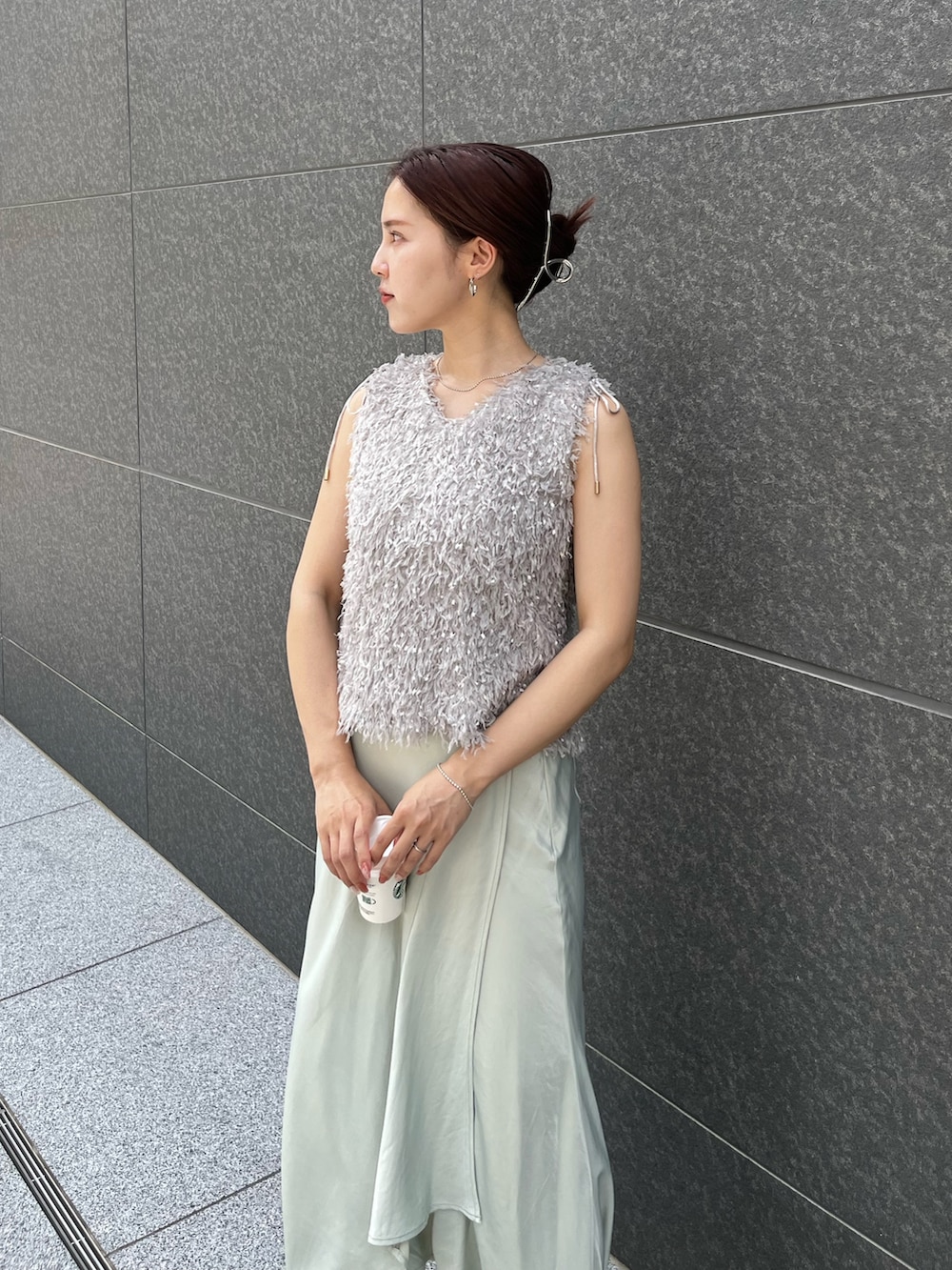 グレー系のTシャツ/カットソー、グリーン系のスカート、ホワイト系のサンダルを着用したレディースの夏コーディネートの4枚目の写真