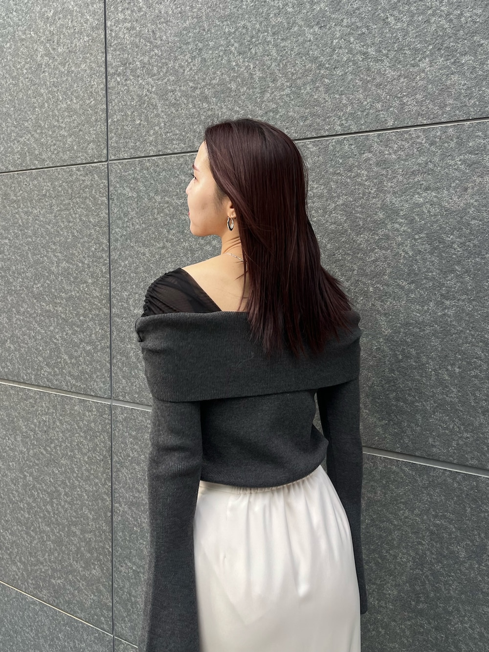 ホワイト系のスカート、ブラウン系のショルダーバッグ、ブラック系のニット/セーターを着用したレディースの冬コーディネートの6枚目の写真