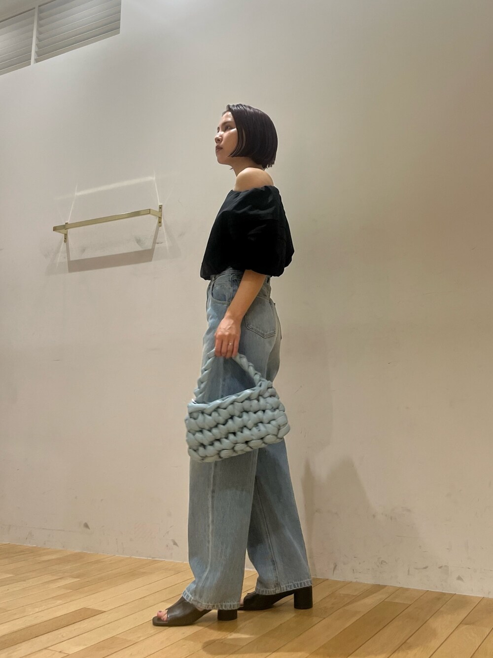 ブルー系のデニムパンツ、ブラック系のシャツ/ブラウス、ブラック系のサンダルを着用したレディースの夏コーディネートの2枚目の写真