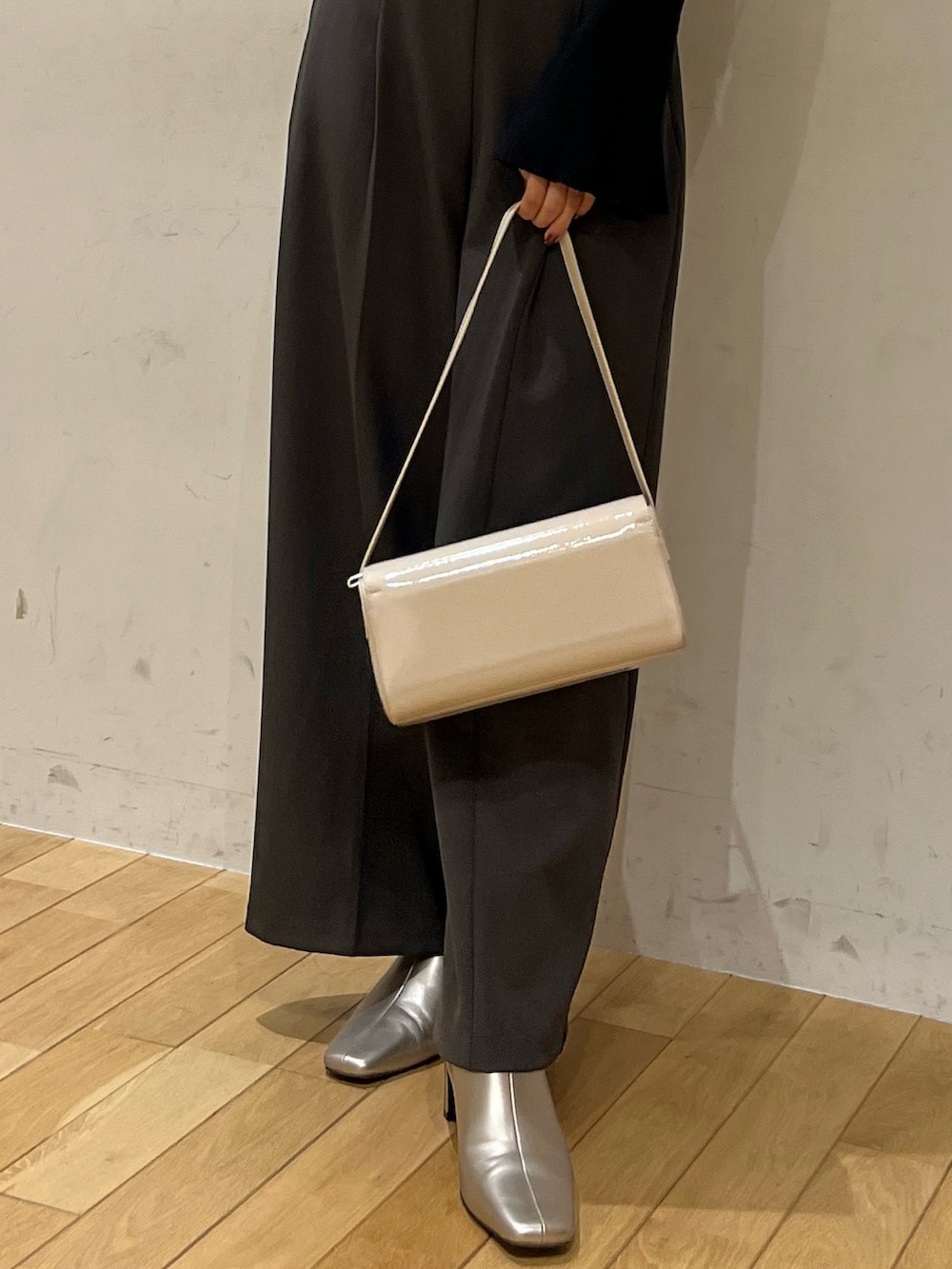 グレー系のその他パンツ、シルバー系のブーツ、ホワイト系のショルダーバッグを着用したレディースの秋コーディネートの5枚目の写真