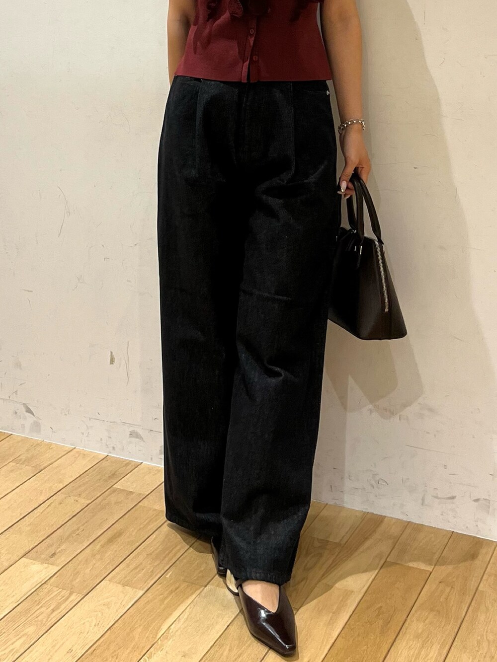 ブラック系のデニムパンツ、ブラウン系のパンプス、ブラウン系のボストンバッグを着用したレディースの夏コーディネートの6枚目の写真