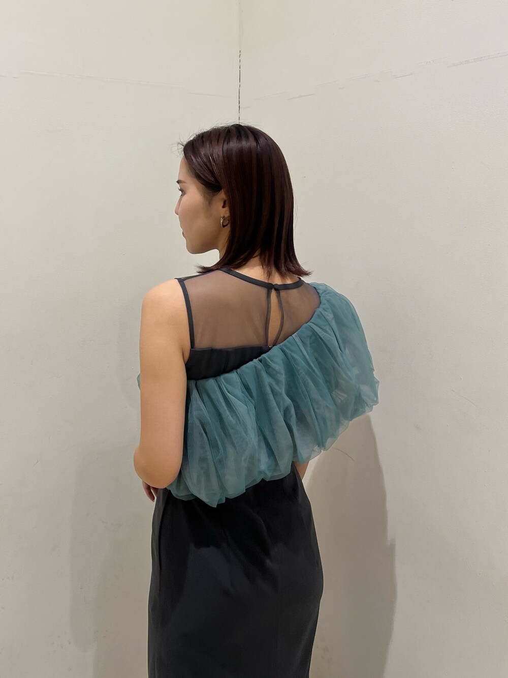 シルバー系のクラッチバッグ、シルバー系のパンプス、グレー系のドレスを着用したレディースの冬コーディネートの7枚目の写真