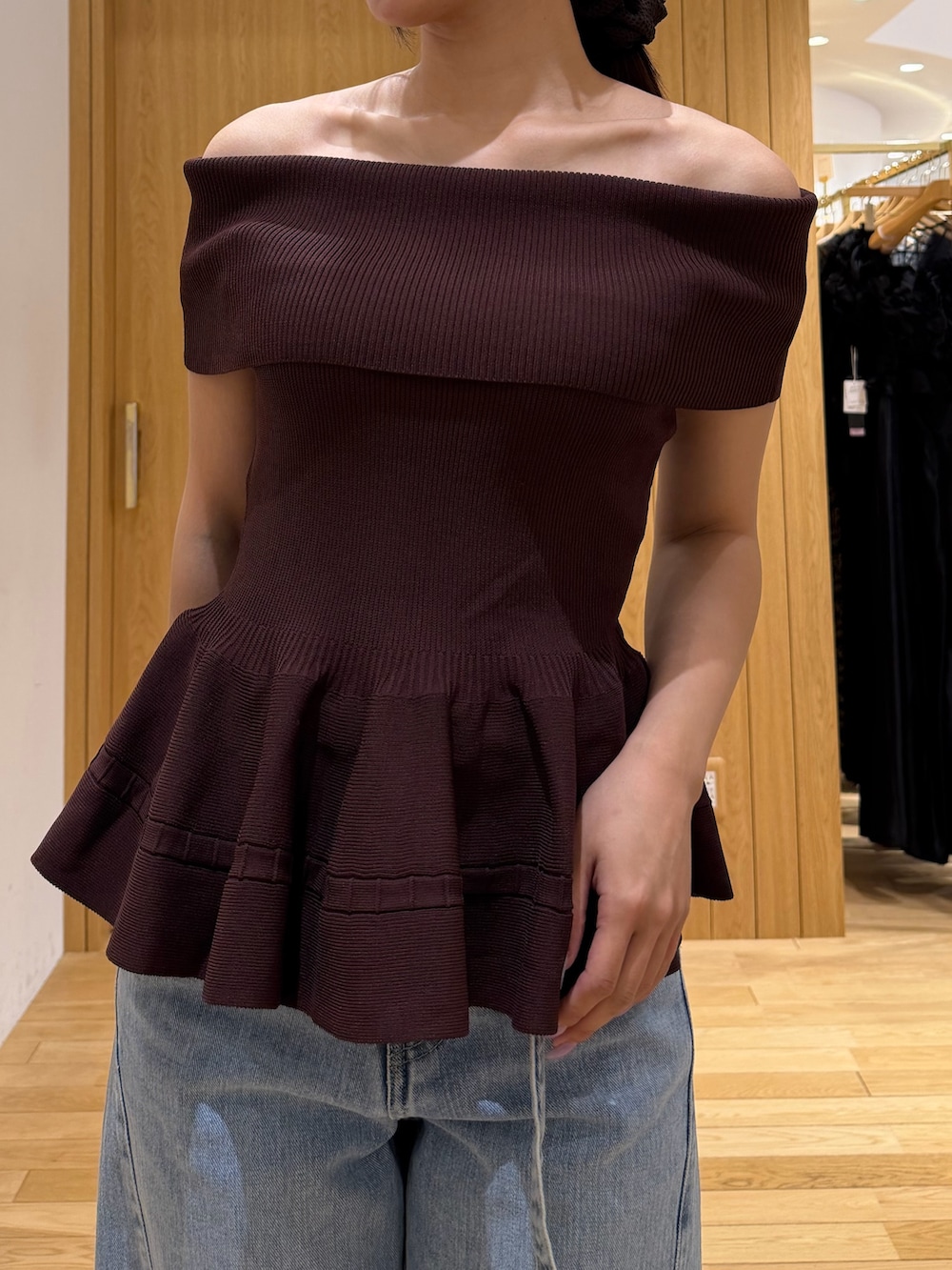 ブラウン系のニット/セーター、ブルー系のデニムパンツ、ホワイト系のハンドバッグを着用したレディースの夏コーディネートの5枚目の写真