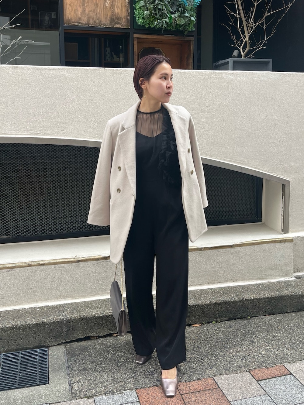 ブラック系のパンツドレス、その他のパンプス、シルバー系のハンドバッグを着用したレディースの冬コーディネートの4枚目の写真