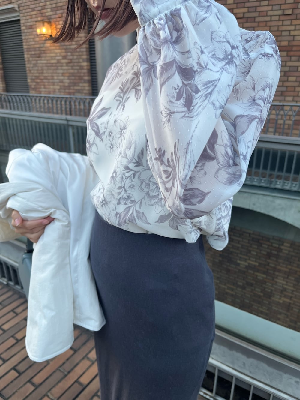 ブルー系のショルダーバッグ、グレー系のスカート、ホワイト系のブルゾンを着用したレディースの冬コーディネートの7枚目の写真