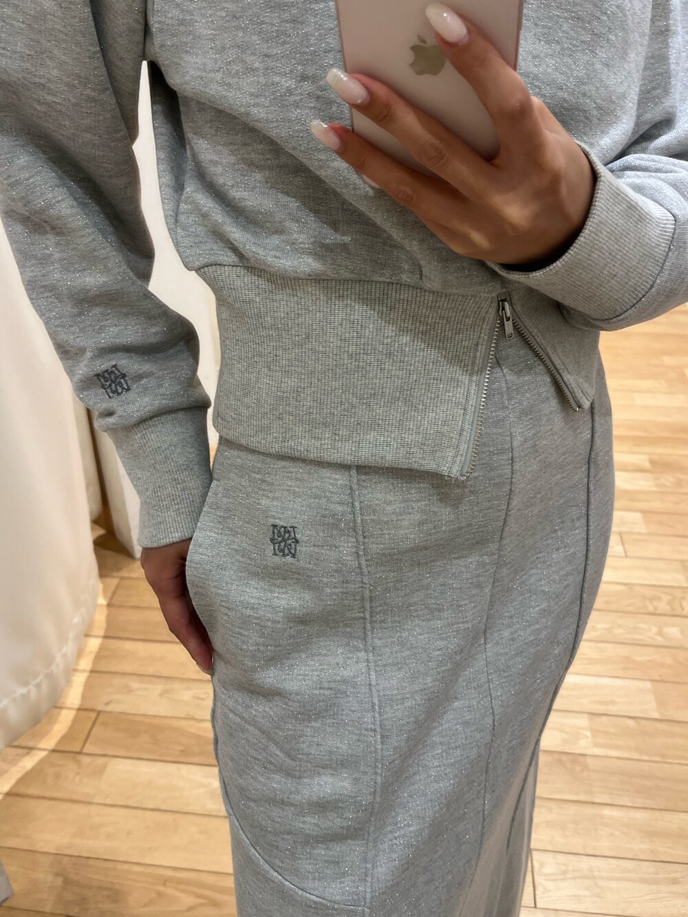 グレー系のスウェット、グレー系のスカート、レッド系のハンドバッグを着用したレディースの秋コーディネートの6枚目の写真