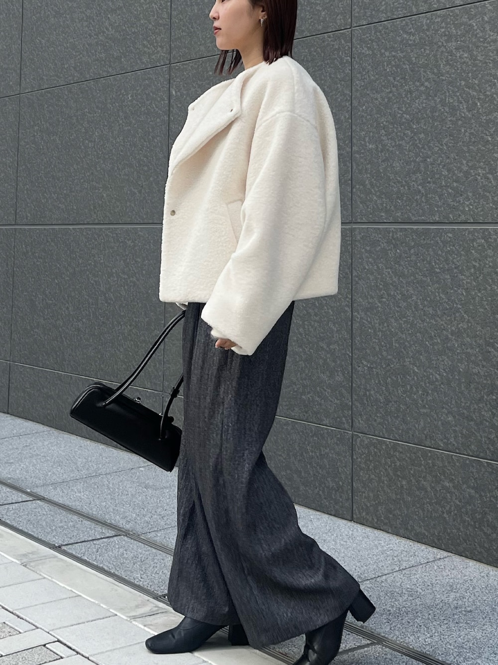 グレー系のその他パンツ、ホワイト系のニット/セーター、ホワイト系のブルゾンを着用したレディースの冬コーディネートの3枚目の写真