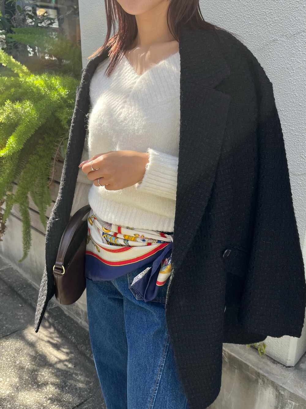 ホワイト系のニット/セーター、ブルー系のデニムパンツ、ブラック系のその他アウターを着用したレディースの冬コーディネートの5枚目の写真