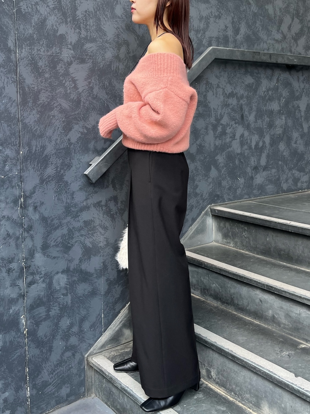 ブラック系のブーツ、ピンク系のニット/セーター、ホワイト系のボストンバッグを着用したレディースの秋コーディネートの2枚目の写真