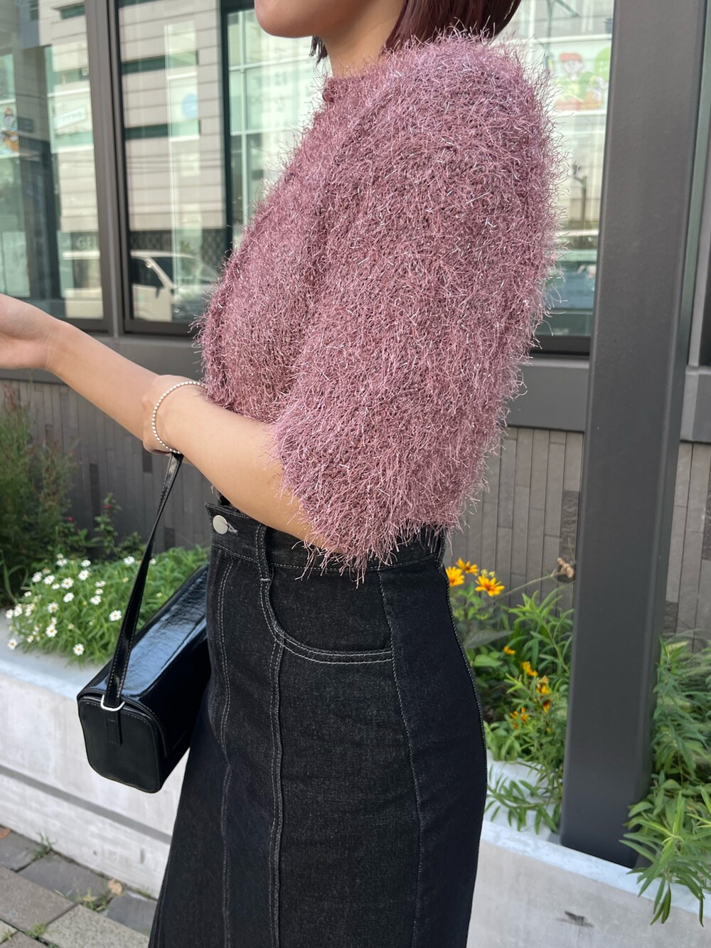 ブラック系のデニムスカート、ピンク系のカーディガン/ボレロ、ブラック系のショルダーバッグを着用したレディースの秋コーディネートの4枚目の写真