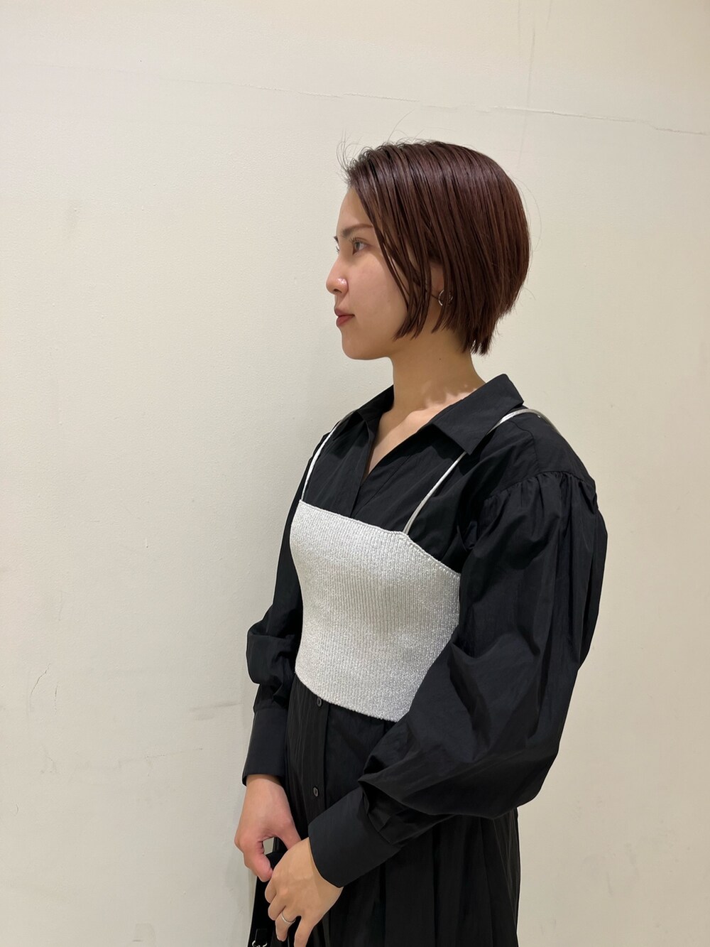 ブラック系のシャツワンピース、ブラック系のハンドバッグ、シルバー系のパンプスを着用したレディースの冬コーディネートの4枚目の写真