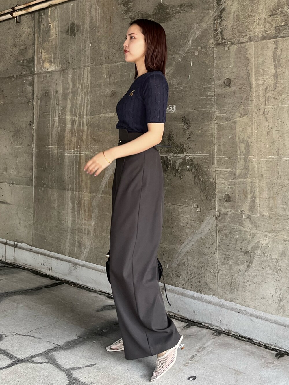 グレー系のその他パンツ、ホワイト系のサンダル、ブルー系のニット/セーターを着用したレディースの春コーディネートの2枚目の写真