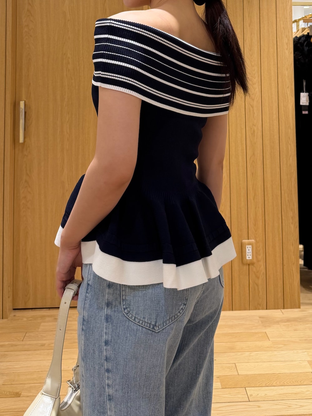 ブルー系のデニムパンツ、ホワイト系のハンドバッグ、ホワイト系のサンダルを着用したレディースの夏コーディネートの5枚目の写真