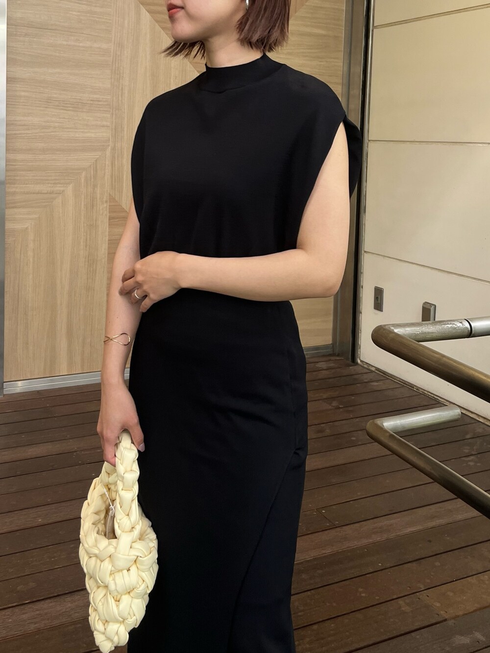 ブラック系のサンダル、ホワイト系のハンドバッグ、ブラック系のニット/セーターを着用したレディースの夏コーディネートの4枚目の写真