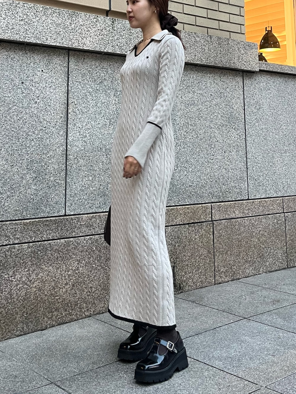 ブラウン系のボストンバッグ、ブラック系のローファー、ベージュ系のワンピースを着用したレディースの秋コーディネートの7枚目の写真