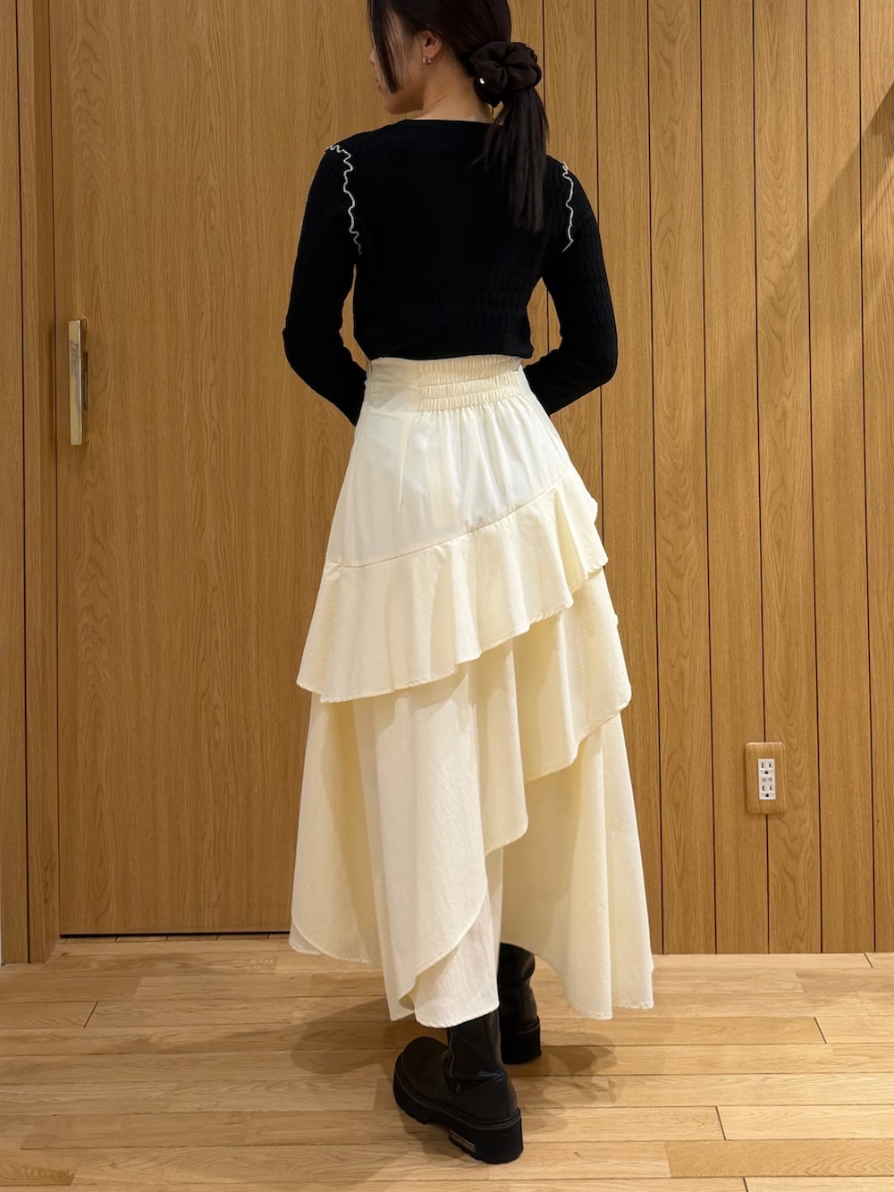 ブラック系のテーラードジャケット、ホワイト系のスカート、ブラック系のニット/セーターを着用したレディースの春コーディネートの5枚目の写真