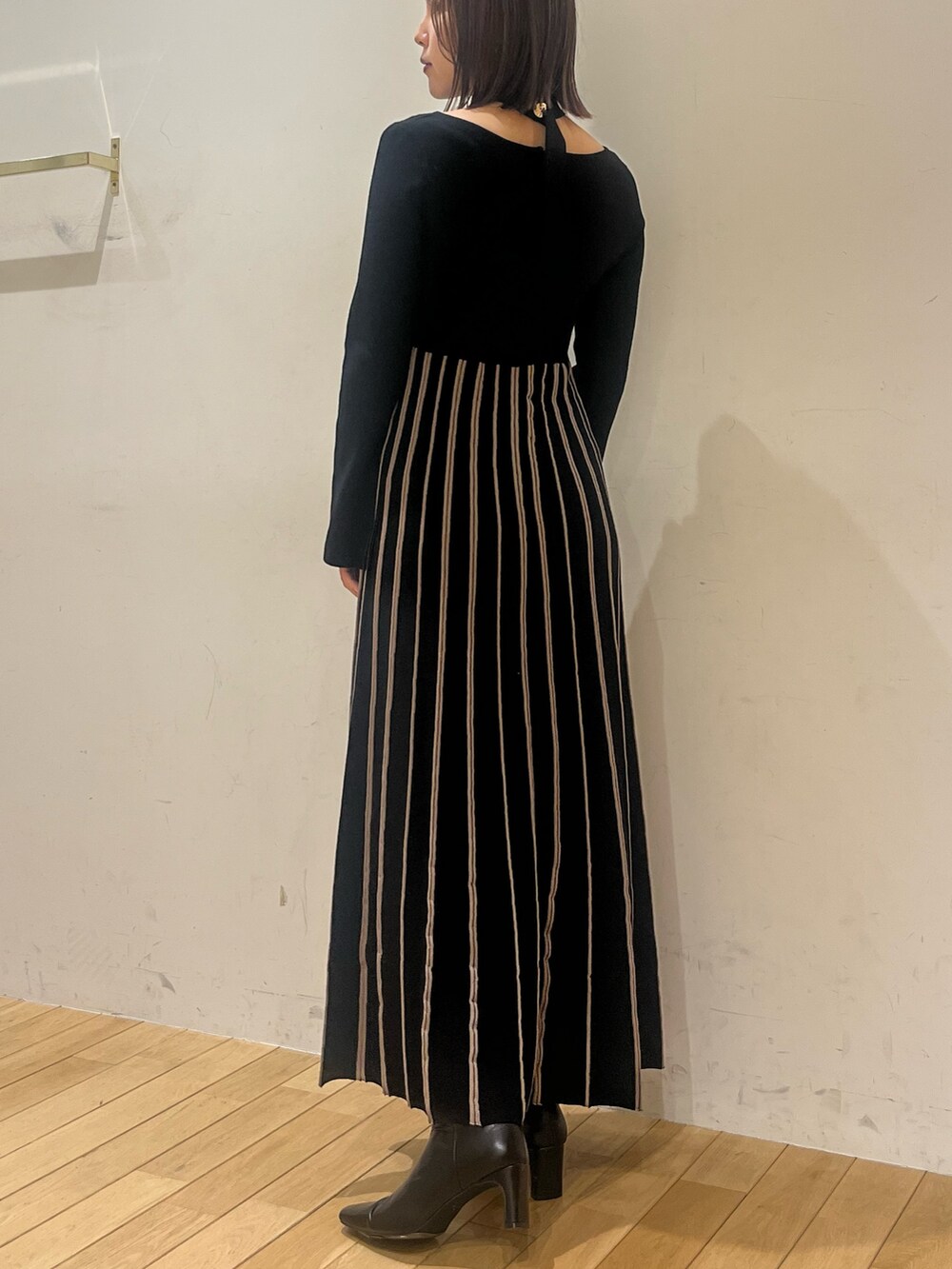 ブラック系のワンピース、ブラック系のブーツを着用したレディースの冬コーディネートの3枚目の写真