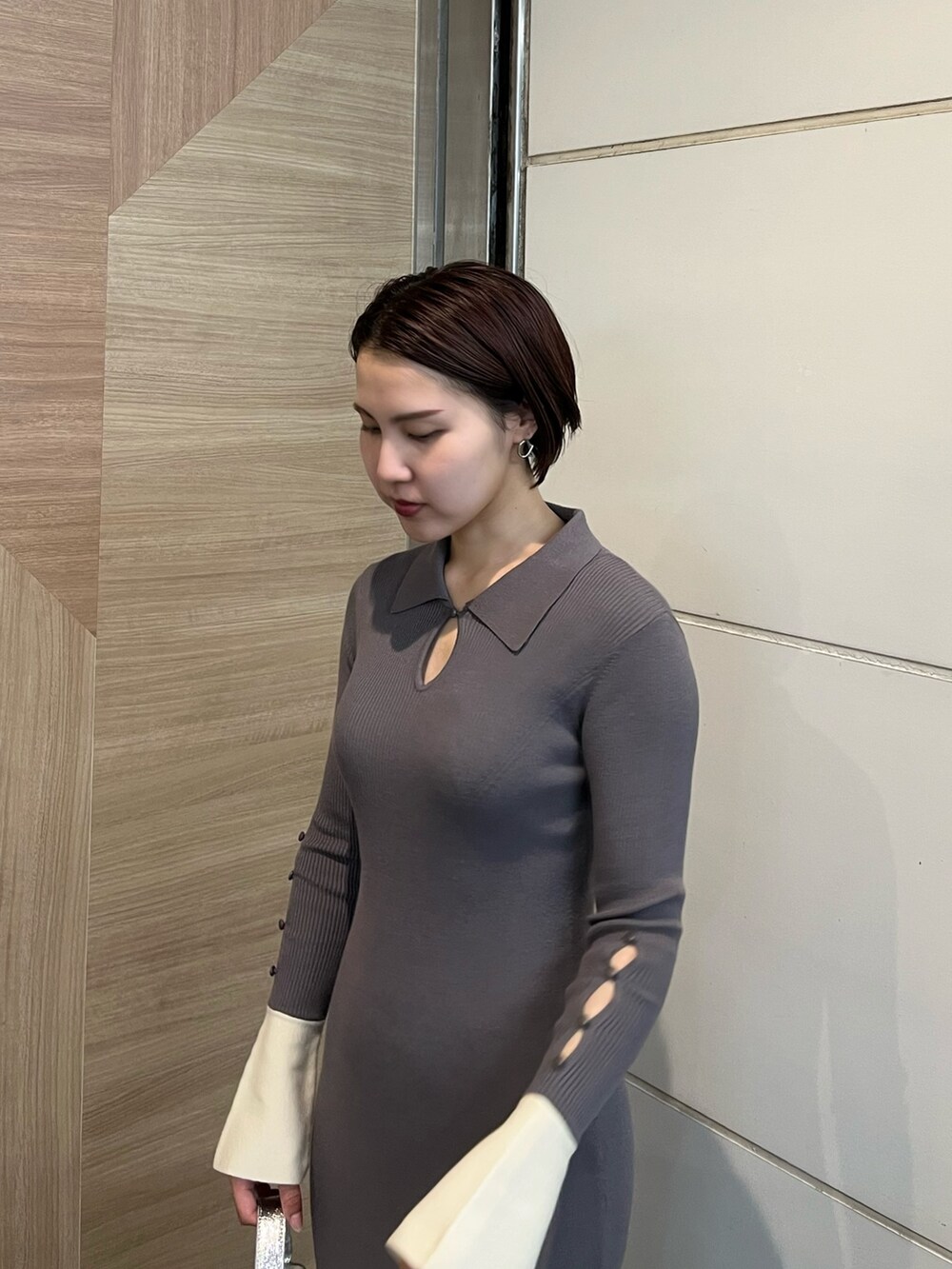 グレー系のワンピース、ホワイト系のスニーカー、シルバー系のショルダーバッグを着用したレディースの冬コーディネートの5枚目の写真