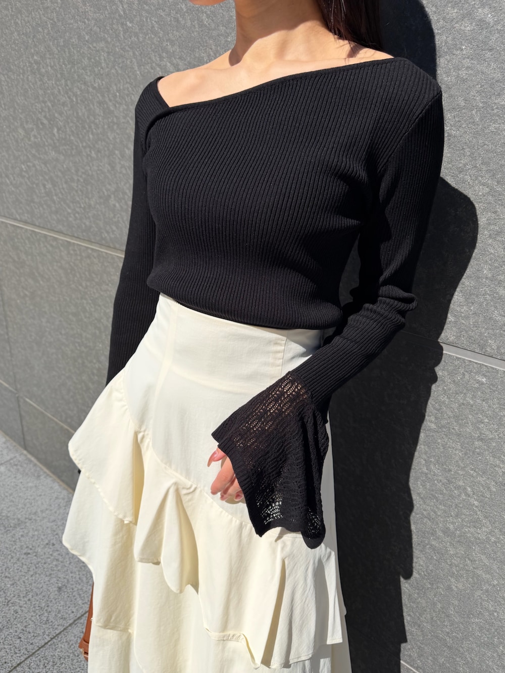 ホワイト系のスカート、ブラック系のニット/セーター、ブラウン系のハンドバッグを着用したレディースの冬コーディネートの5枚目の写真