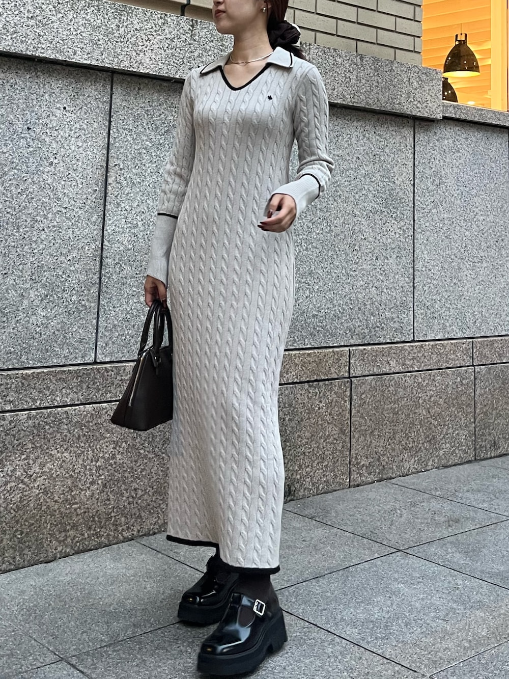 ブラウン系のボストンバッグ、ブラック系のローファー、ベージュ系のワンピースを着用したレディースの秋コーディネートの6枚目の写真