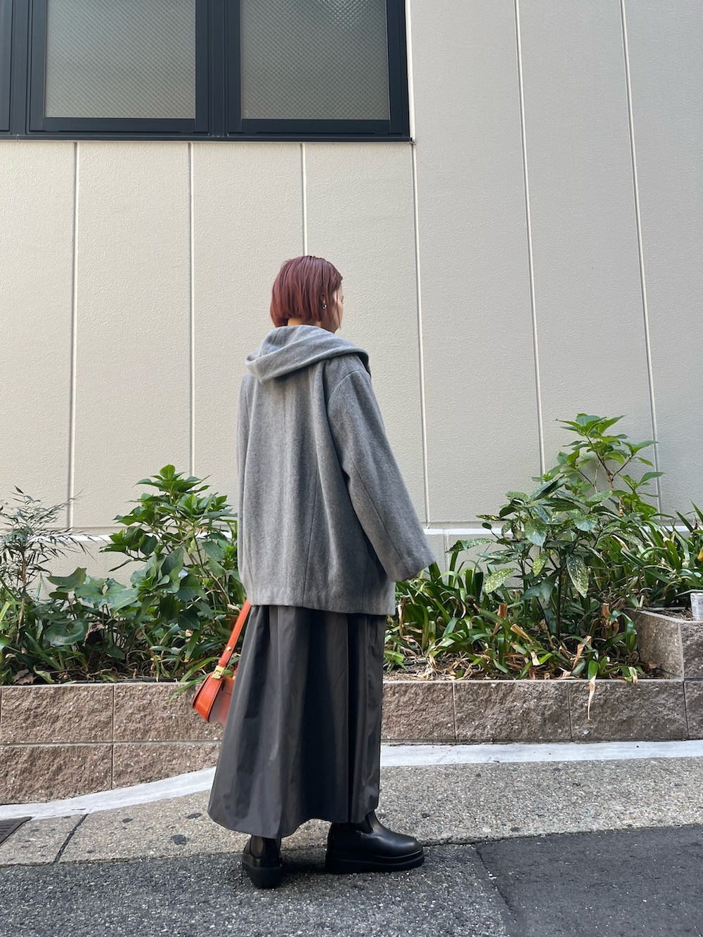 グレー系のワンピース、オレンジ系のショルダーバッグ、グレー系のその他アウターを着用したレディースの秋コーディネートの4枚目の写真