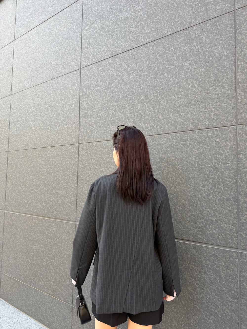 ブラック系のその他パンツ、ピンク系のTシャツ/カットソー、グレー系のテーラードジャケットを着用したレディースの冬コーディネートの6枚目の写真