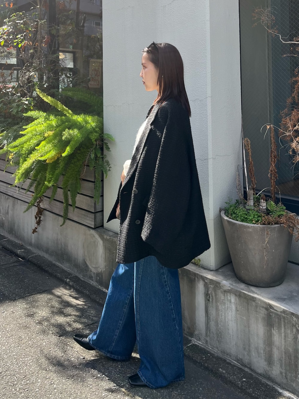 ホワイト系のニット/セーター、ブルー系のデニムパンツ、ブラック系のその他アウターを着用したレディースの冬コーディネートの2枚目の写真