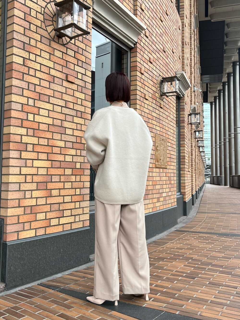 ホワイト系のカーディガン/ボレロ、ベージュ系のパンツドレス、ブラウン系のパンプスを着用したレディースの秋コーディネートの5枚目の写真