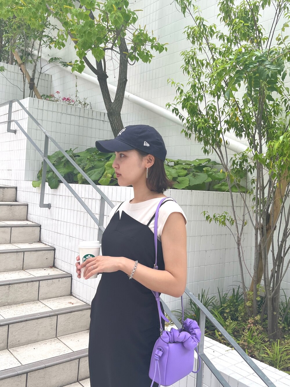 ブラック系のワンピース、ホワイト系のニット/セーター、パープル系のハンドバッグを着用したレディースの夏コーディネートの4枚目の写真