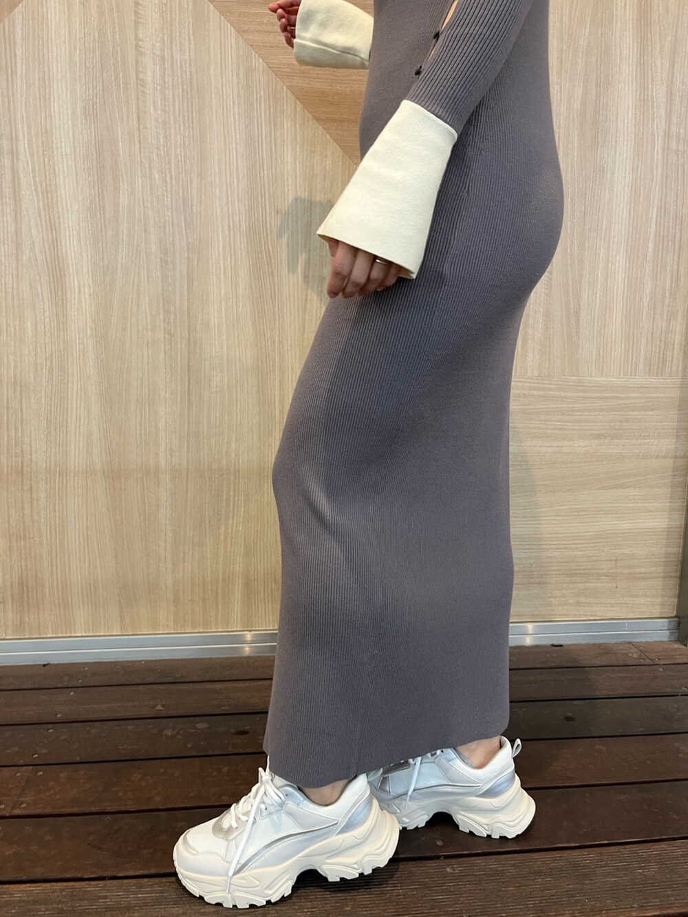 グレー系のワンピース、ホワイト系のスニーカー、シルバー系のショルダーバッグを着用したレディースの冬コーディネートの7枚目の写真