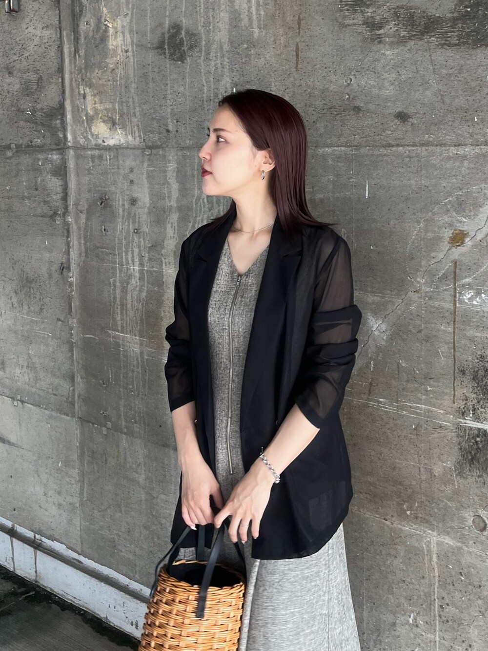 ブラック系のテーラードジャケット、ブラウン系のワンピース、ブラウン系のハンドバッグを着用したレディースの夏コーディネートの4枚目の写真