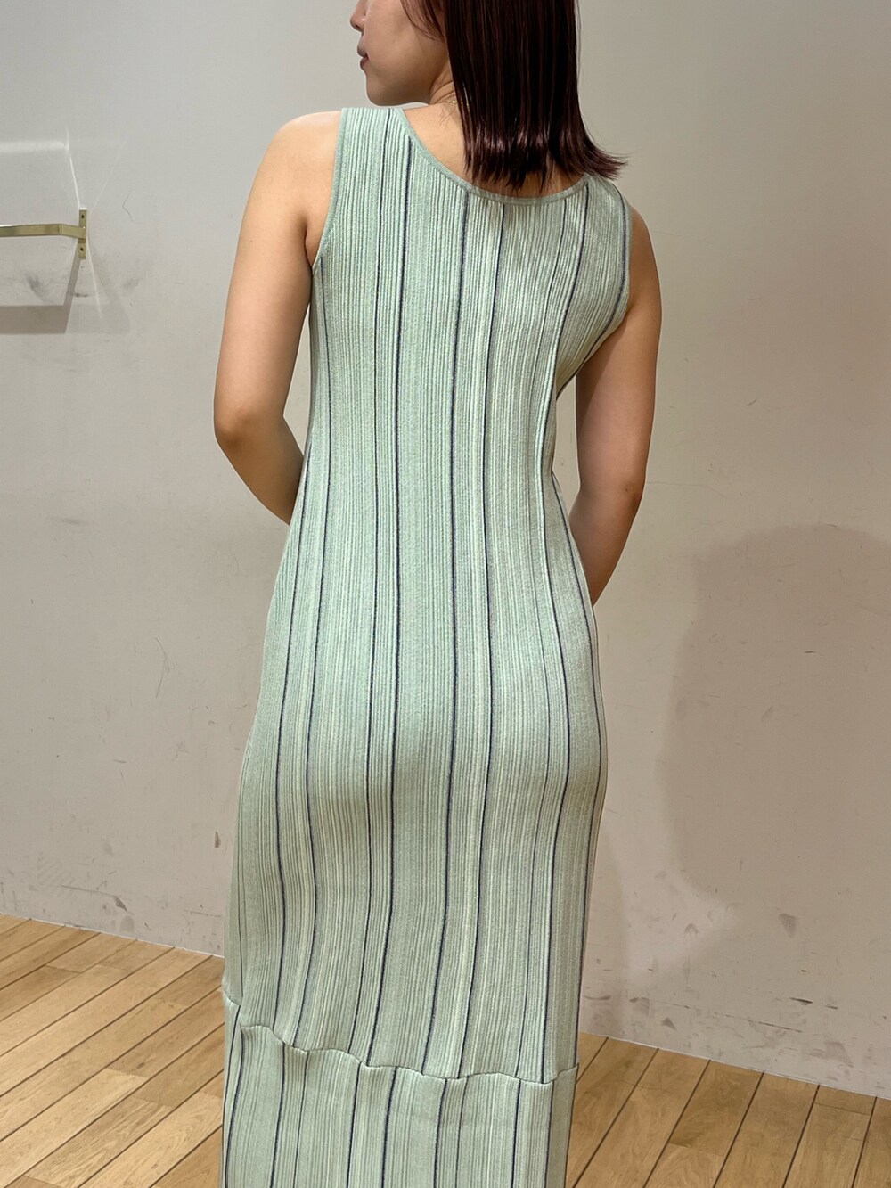 ホワイト系のサンダル、ホワイト系のテーラードジャケット、グリーン系のワンピースを着用したレディースの春コーディネートの5枚目の写真