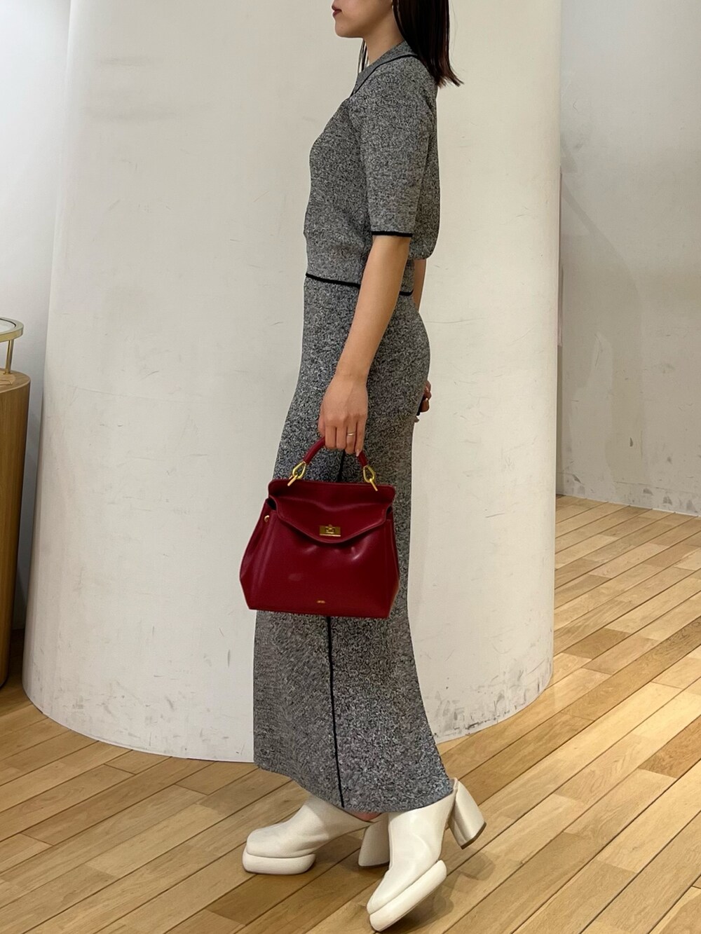 ブラック系のワンピース、レッド系のハンドバッグ、ホワイト系のサンダルを着用したレディースの春コーディネートの2枚目の写真