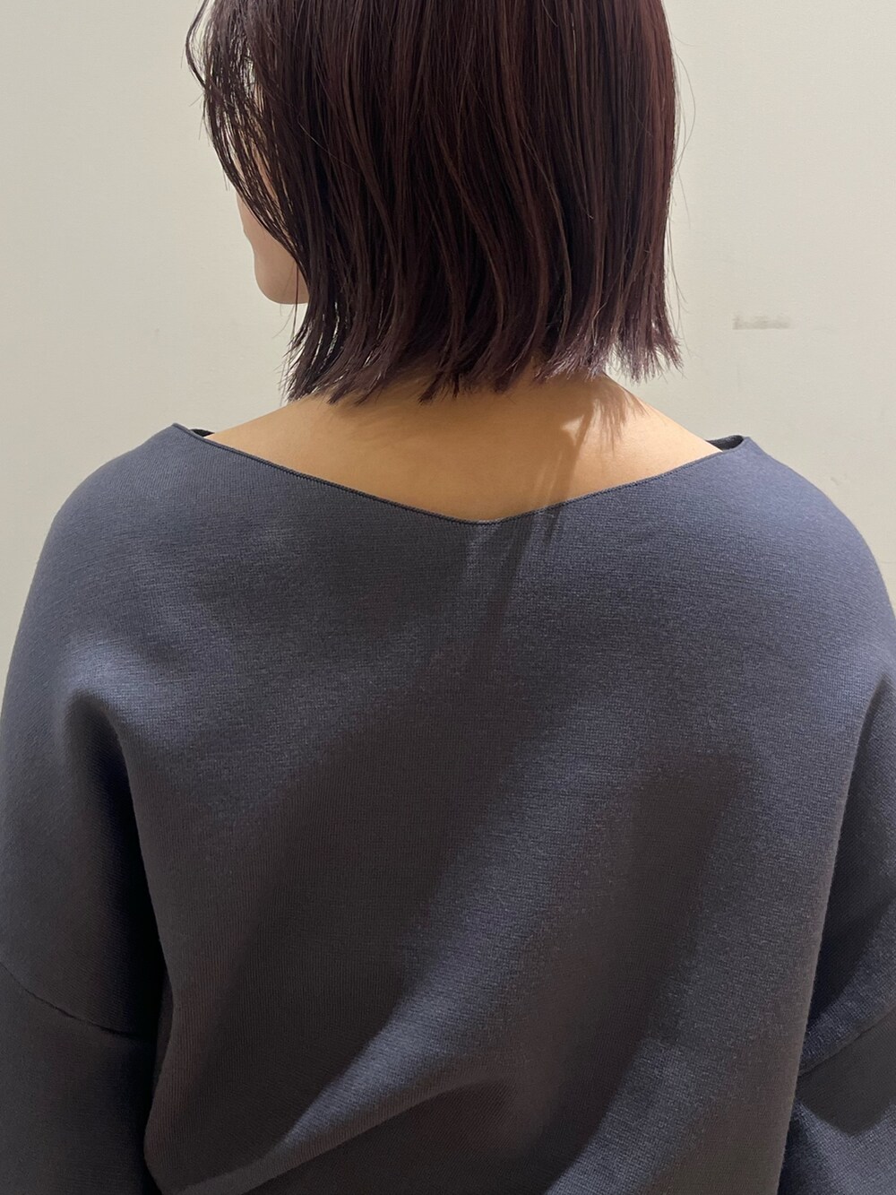 グレー系のスカート、グレー系のニット/セーター、シルバー系のブーツを着用したレディースの秋コーディネートの7枚目の写真