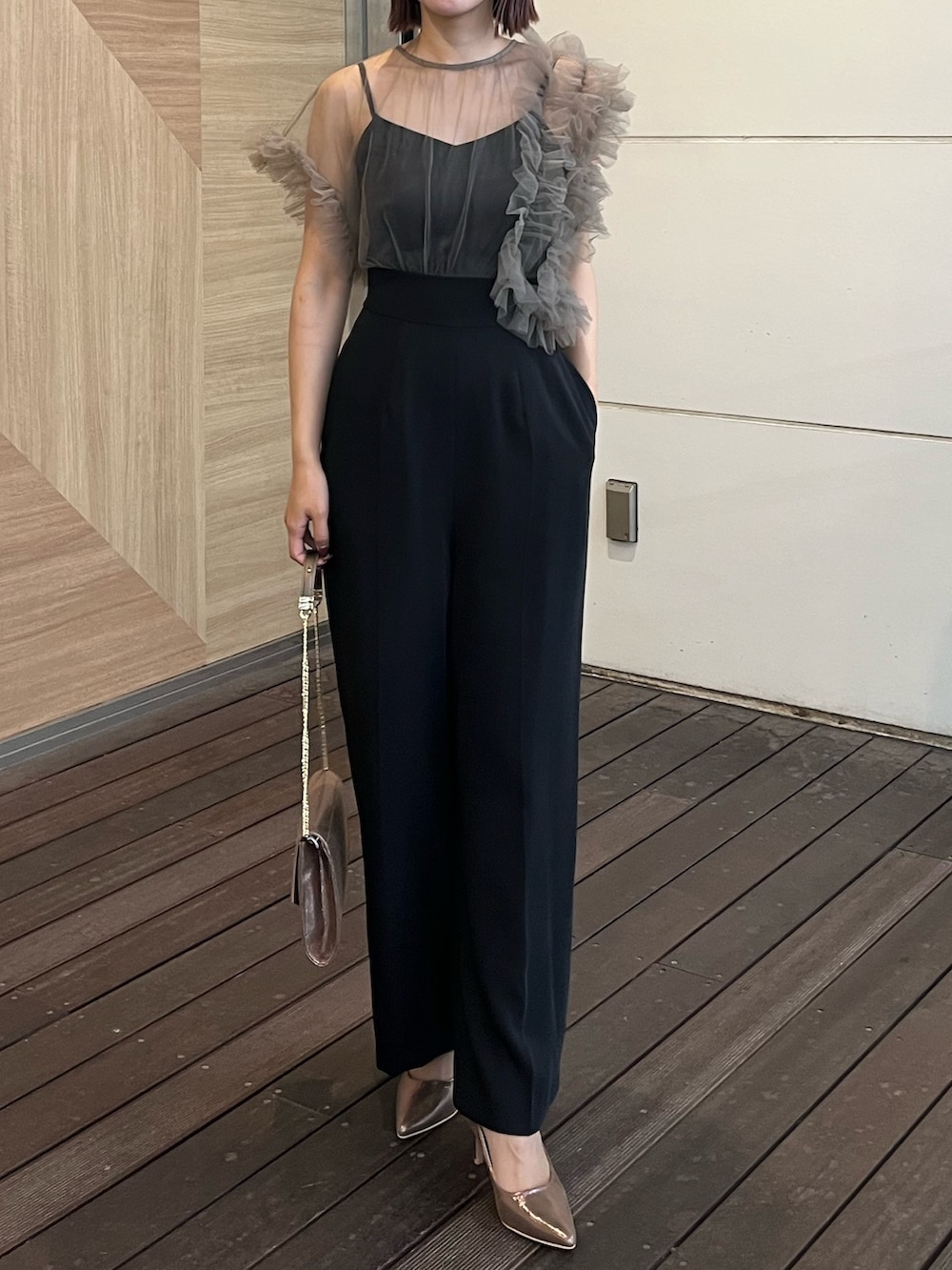 ゴールド系のハンドバッグ、その他のパンツドレス、グレー系のテーラードジャケットを着用したレディースの秋コーディネートの5枚目の写真