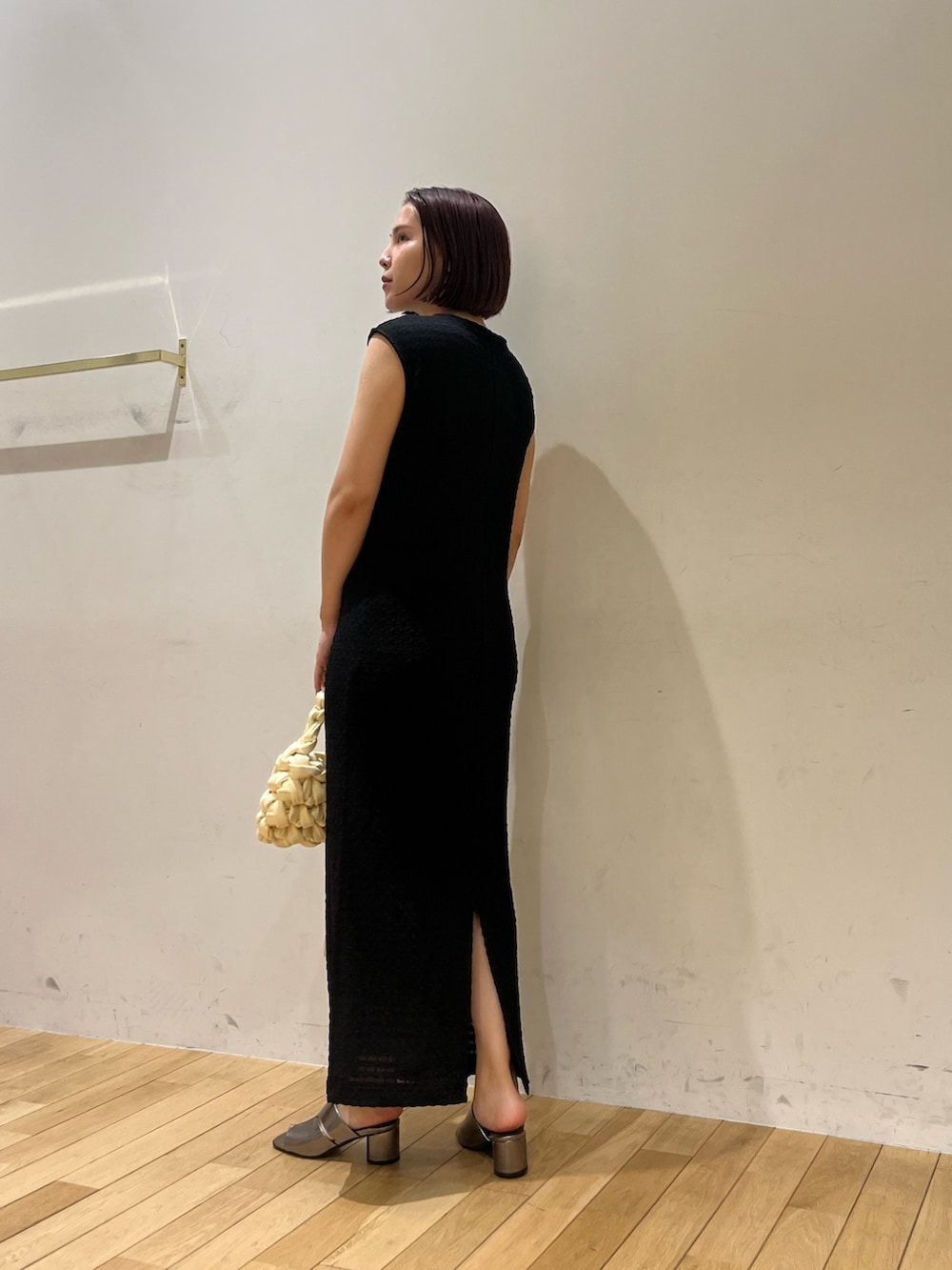 ホワイト系のハンドバッグ、ブラック系のワンピース、その他のサンダルを着用したレディースの夏コーディネートの5枚目の写真