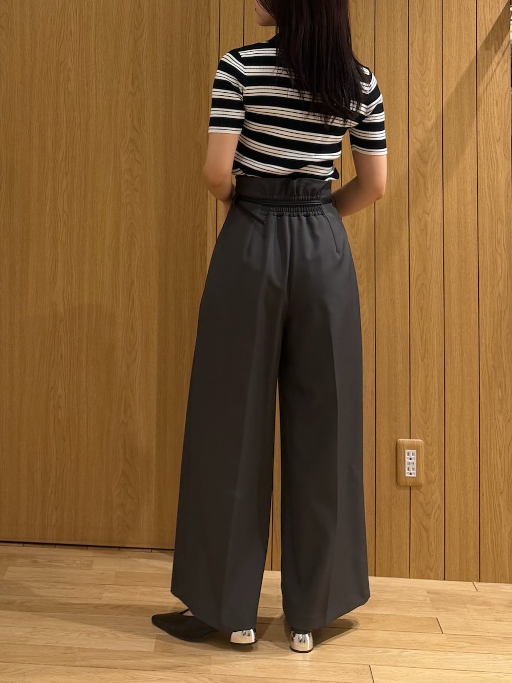 グレー系のその他パンツ、ブラック系のニット/セーター、ブラック系のパンプスを着用したレディースの春コーディネートの3枚目の写真