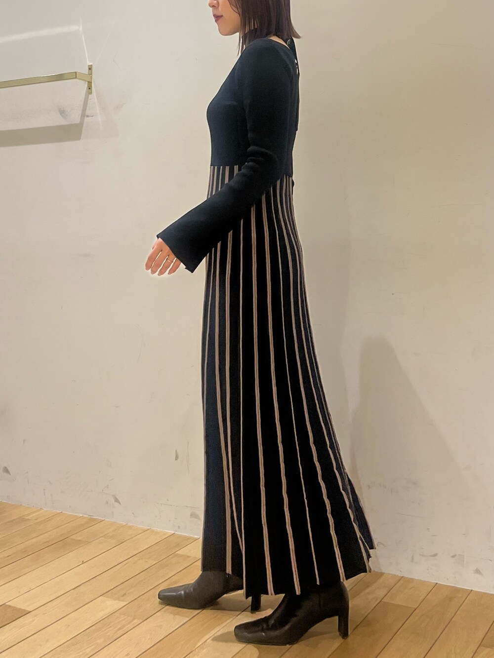 ブラック系のワンピース、ブラック系のブーツを着用したレディースの冬コーディネートの2枚目の写真