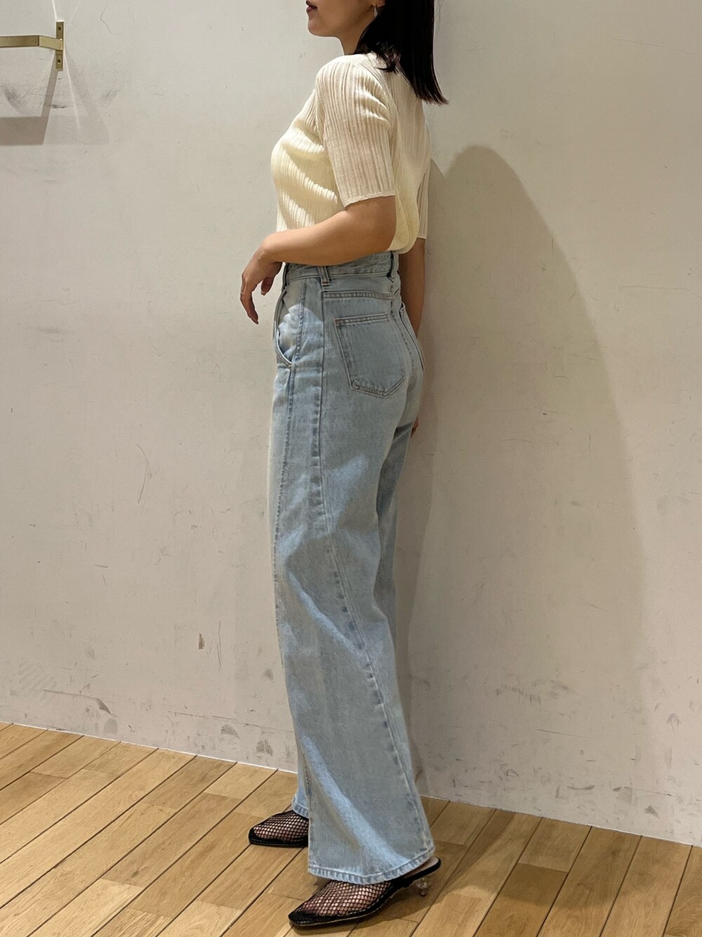 ブルー系のデニムパンツ、ブラック系のサンダル、ホワイト系のTシャツ/カットソーを着用したレディースの春コーディネートの2枚目の写真