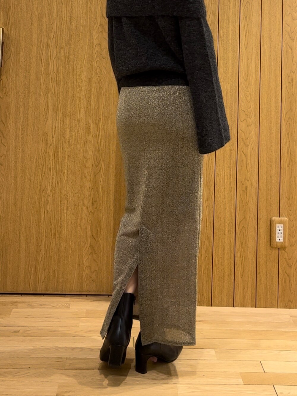 ゴールド系のスカート、ブラック系のブーツ、グレー系のニット/セーターを着用したレディースの冬コーディネートの4枚目の写真