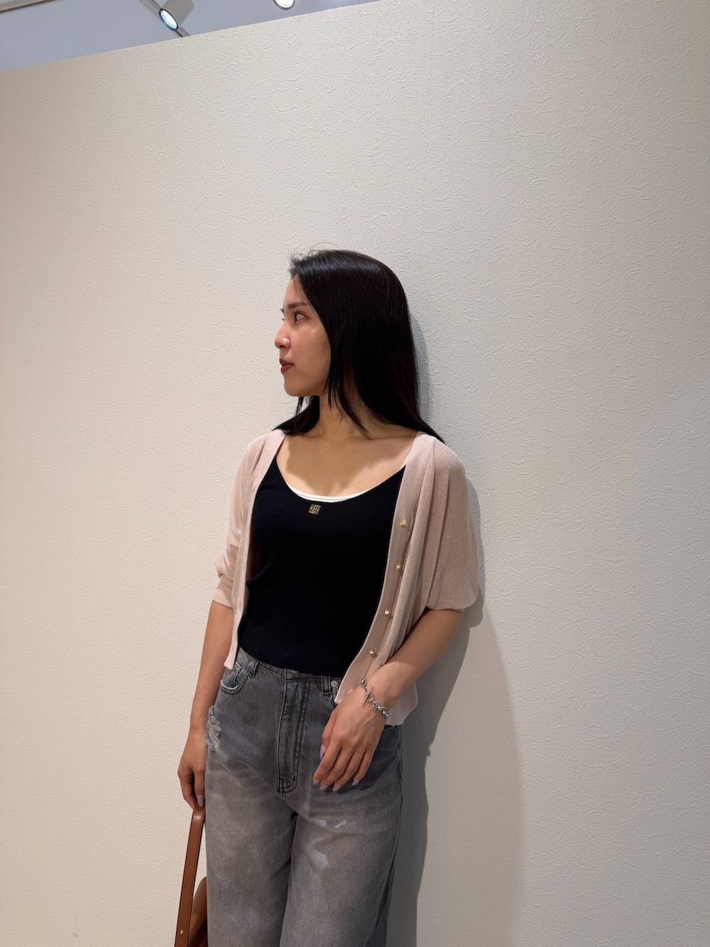 ブラック系のパンプス、ブラウン系のハンドバッグ、ブラック系のタンクトップを着用したレディースの夏コーディネートの4枚目の写真