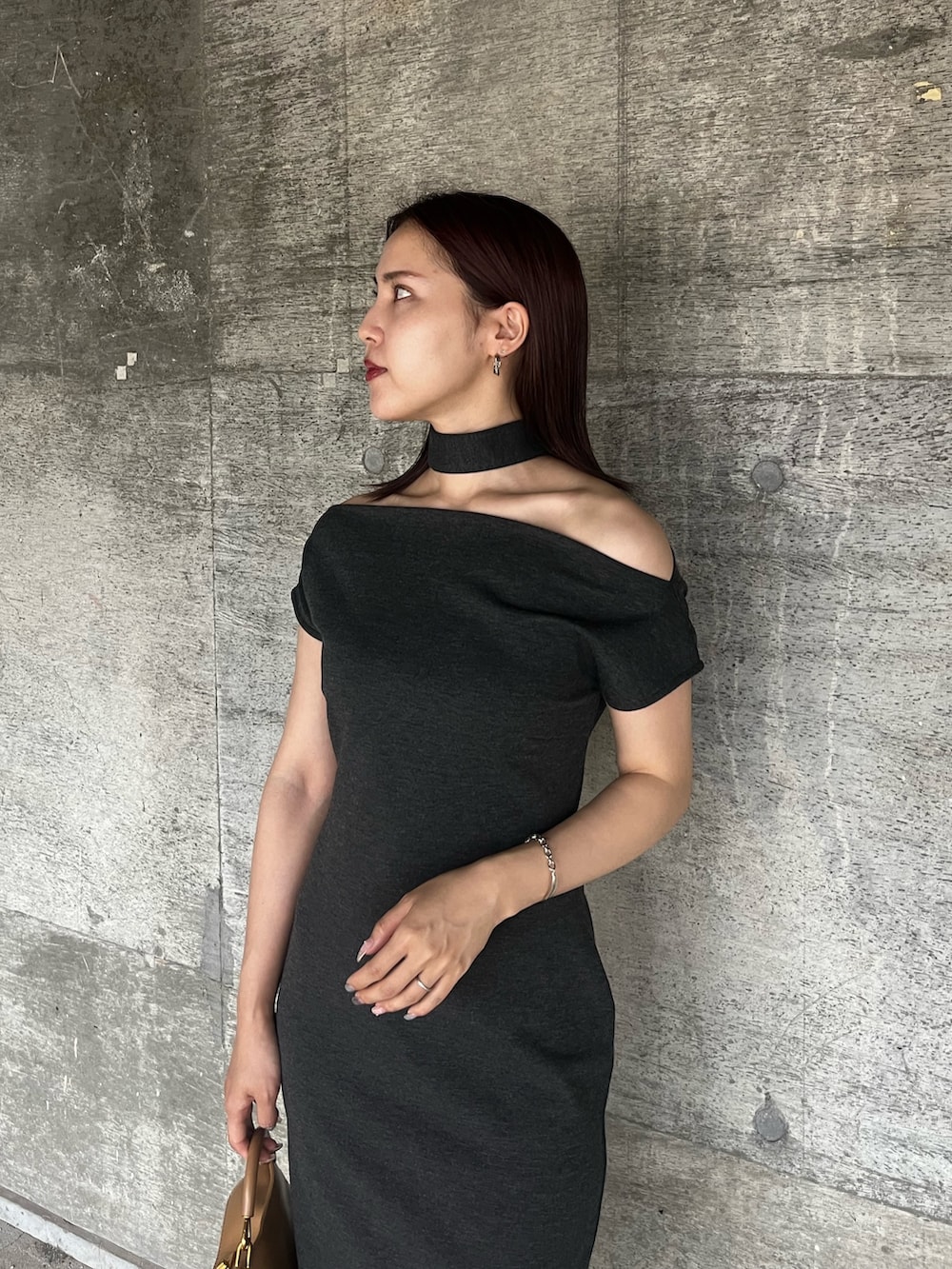 グレー系のワンピース、ブラウン系のハンドバッグ、ブラック系のサンダルを着用したレディースの夏コーディネートの4枚目の写真