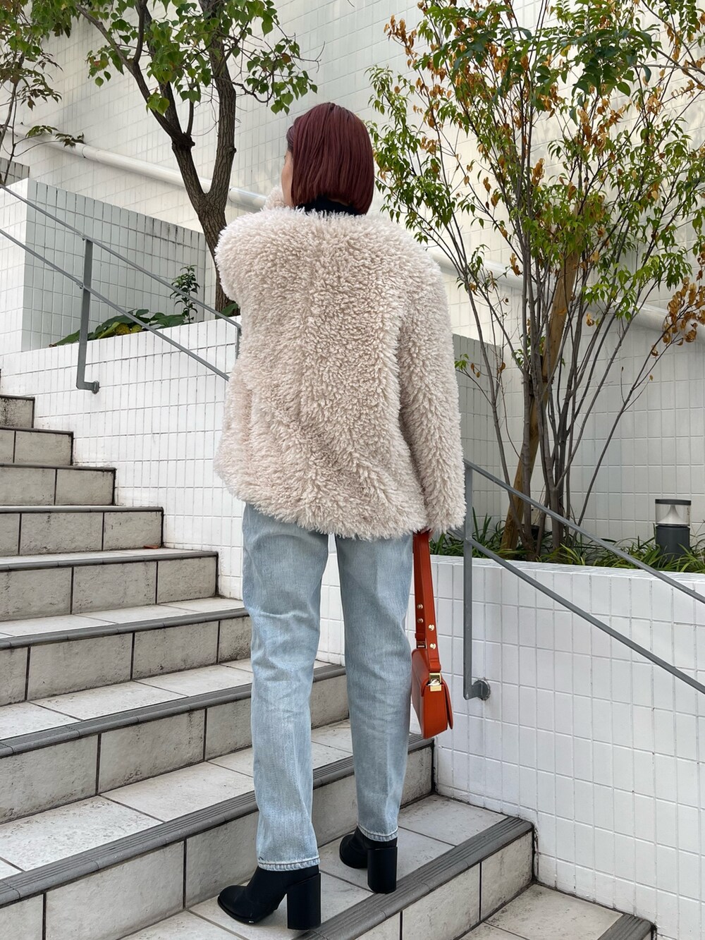 ブルー系のニット/セーター、ホワイト系のその他アウター、ブルー系のデニムパンツを着用したレディースの秋コーディネートの4枚目の写真
