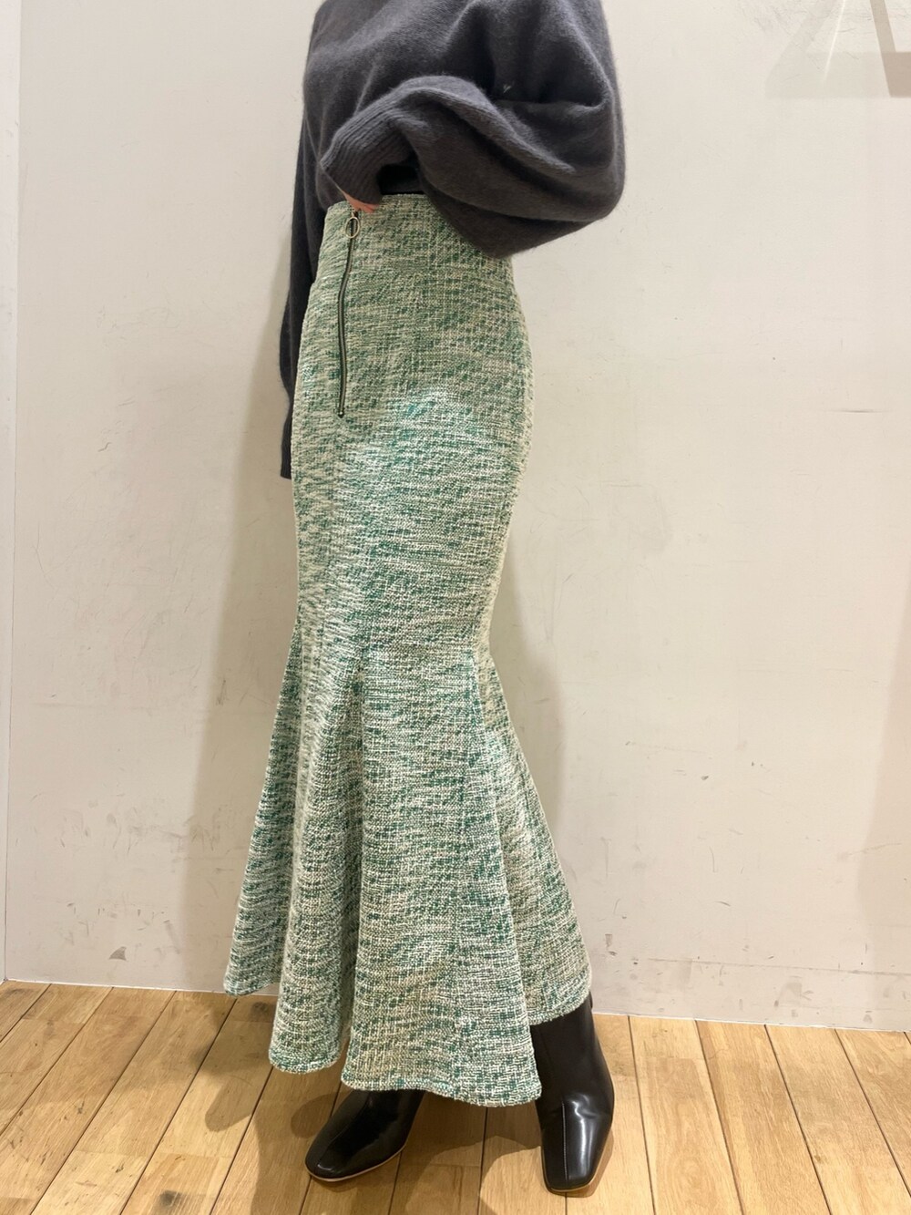 グレー系のニット/セーター、ブラック系のショルダーバッグ、ブラック系のブーツを着用したレディースの秋コーディネートの4枚目の写真