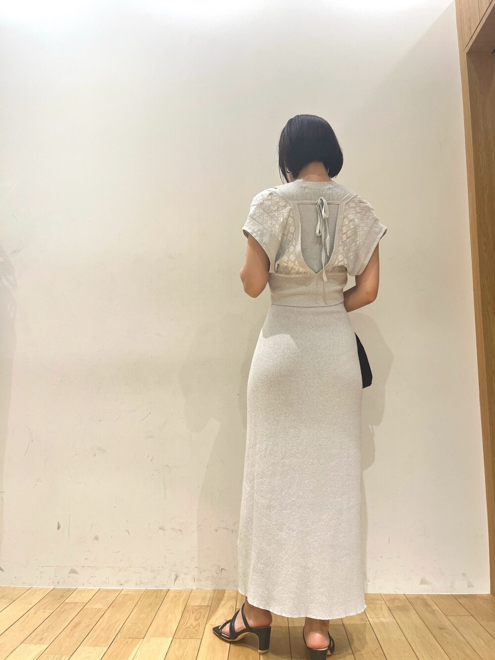 ベージュ系のハンドバッグ、ブルー系のワンピースを着用したレディースの夏コーディネートの4枚目の写真