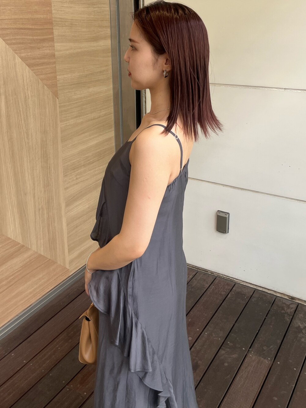 グレー系のワンピース、ブラウン系のハンドバッグ、ブラック系のサンダルを着用したレディースの夏コーディネートの6枚目の写真