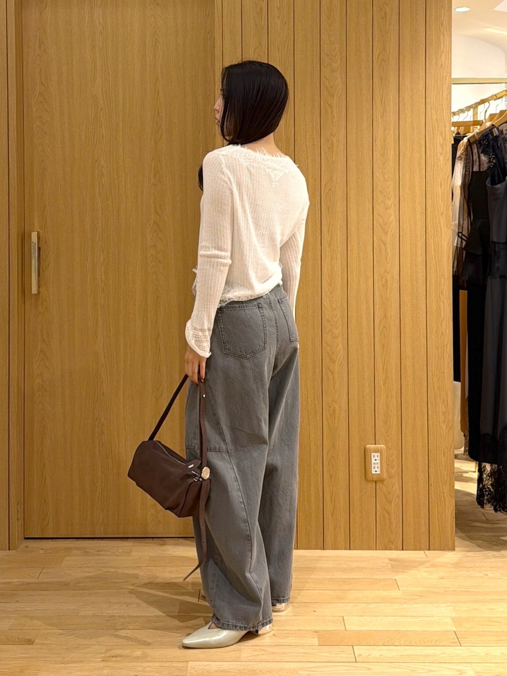 ホワイト系のカーディガン/ボレロ、グレー系のデニムパンツ、ブラウン系のハンドバッグを着用したレディースの秋コーディネートの2枚目の写真